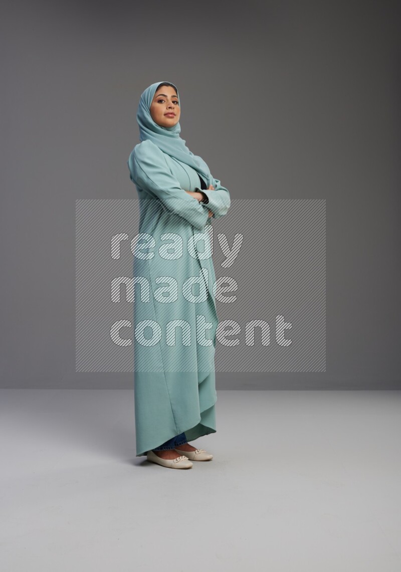 Saudi Woman wearing Abaya standing with crossed arms on Gray background