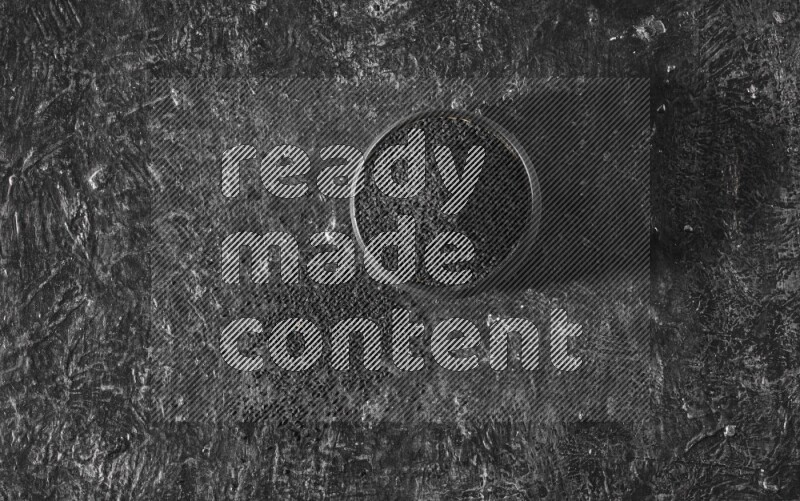 وعاء فخاري أسود ممتلئ ببذور حبة البركة علي خلفية سوداء