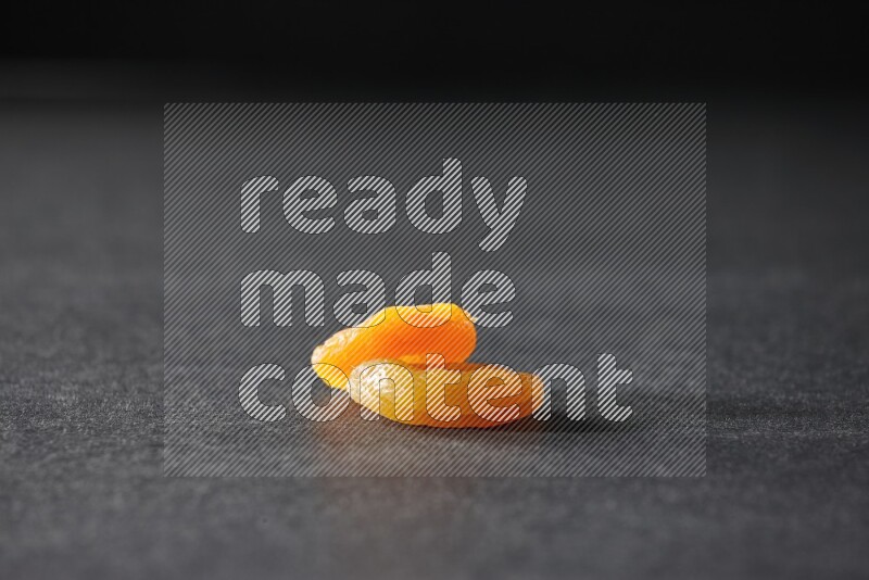 Two dried apricots on a black background in different angles
