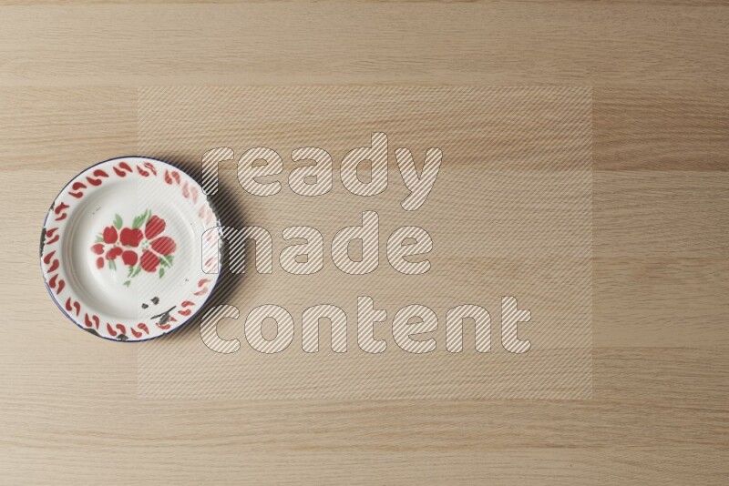 صحن معدني عتيق على خلفية خشبية فاتحة