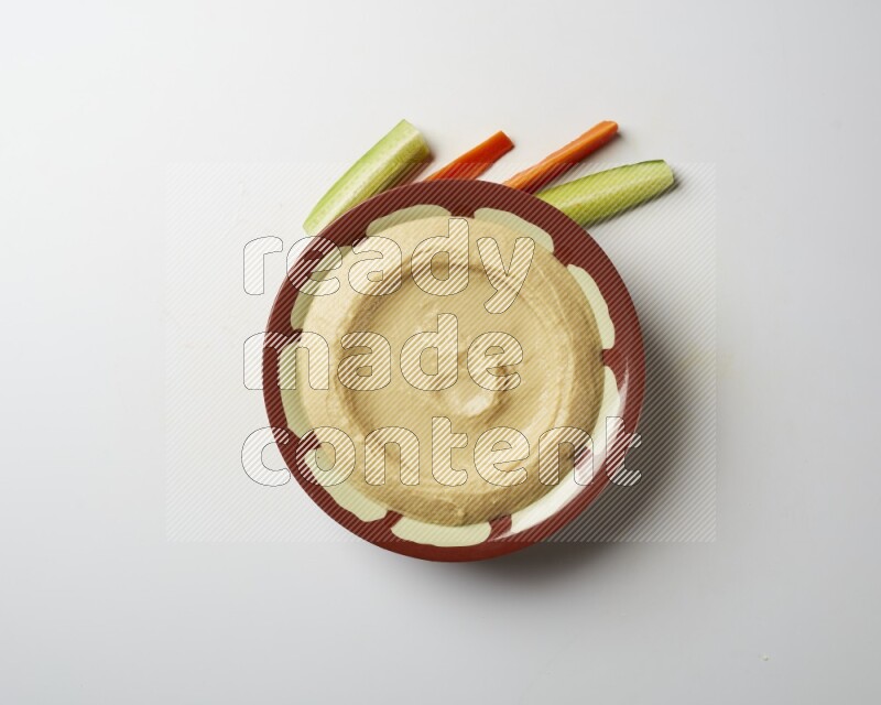 Plain hummus in a traditional plate on a white background