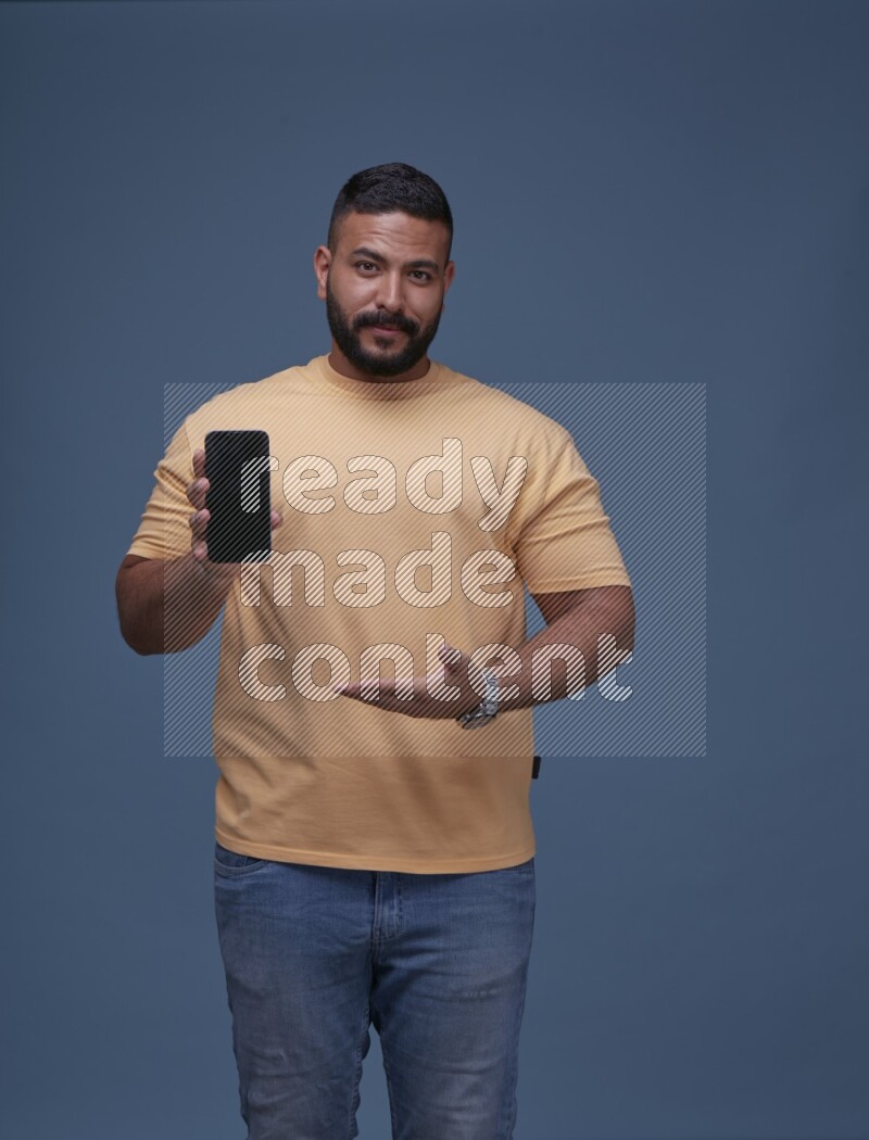 A man Showing His Smart Phone on Blue Background wearing Orange T-shirt