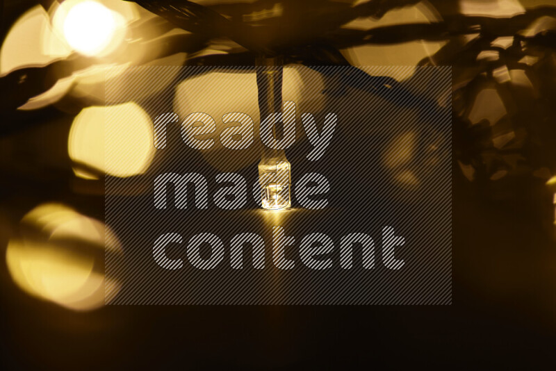Light bulbs glowing against backdrop of golden bokeh