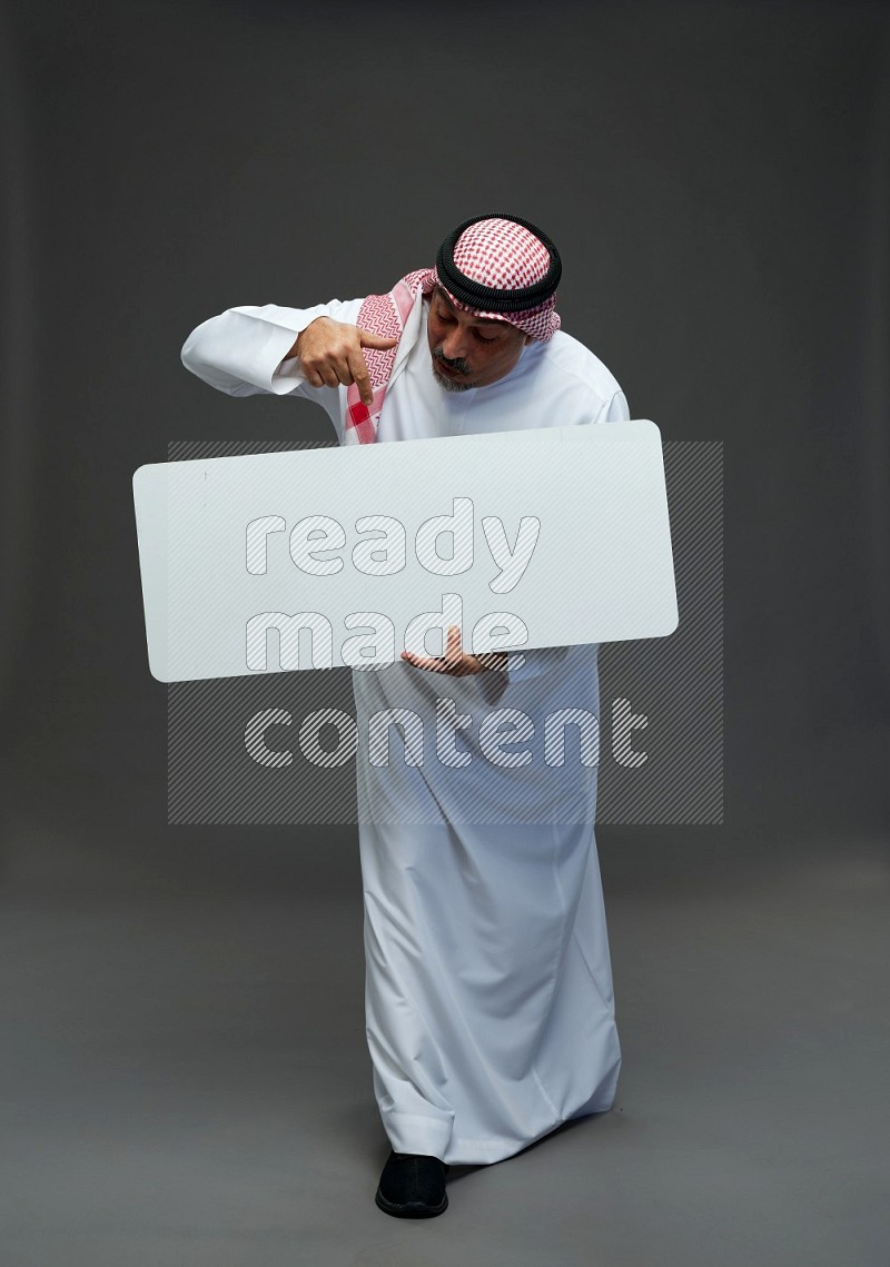 Saudi man with shomag Standing holding social media sing on gray background