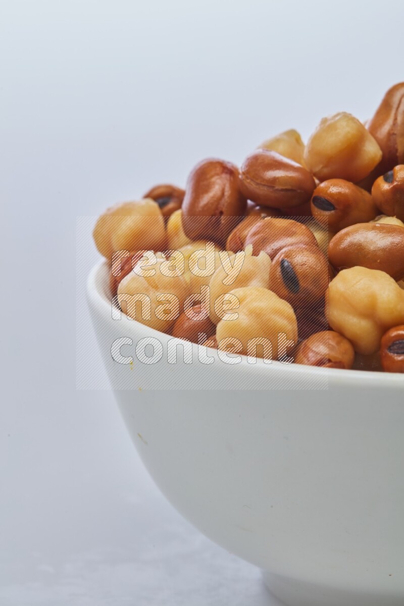 Close up shot of cooked fava beans (foul) & chickpeas on white background