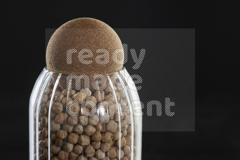 Chickpeas in a glass jar on black background