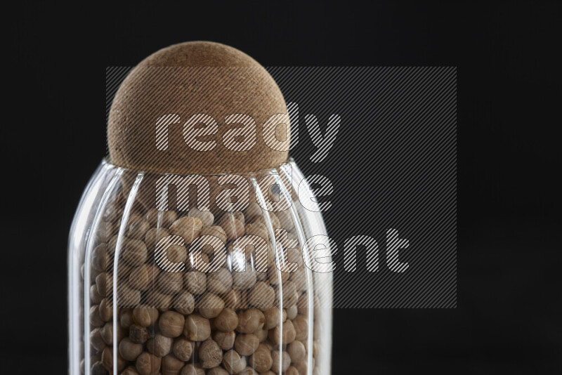 Chickpeas in a glass jar on black background