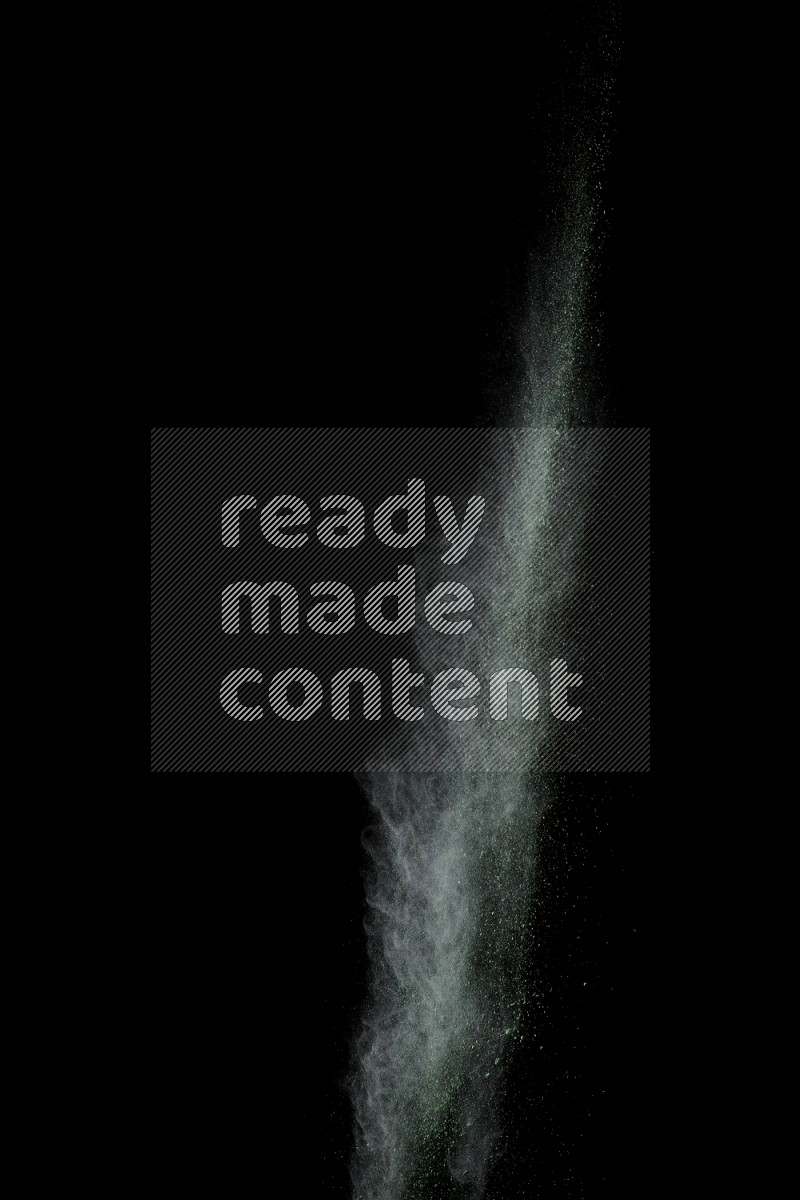 A side view of green powder explosion on black background