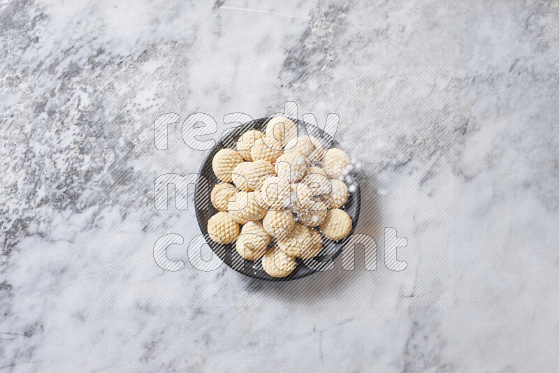 Kahk in black pottery plate on grey marble background