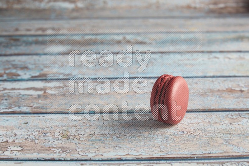 45º Shot of Red Velvet macaron on light blue wooden background