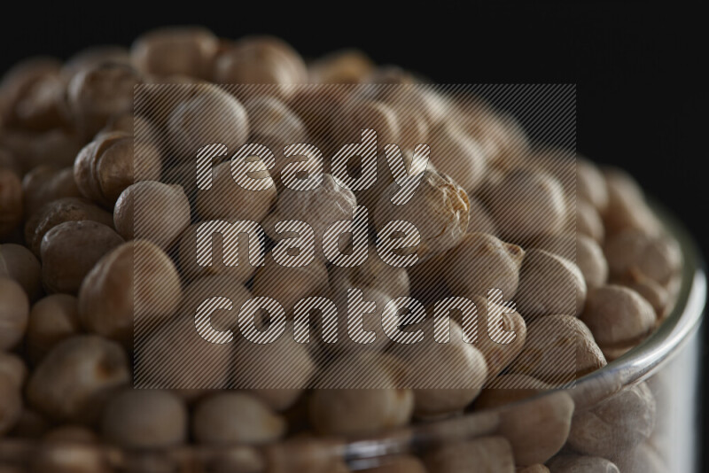 Chickpeas in a glass jar on black background