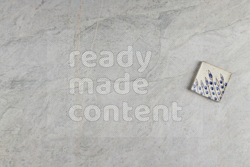 A decorative pottery coaster on grey marble background