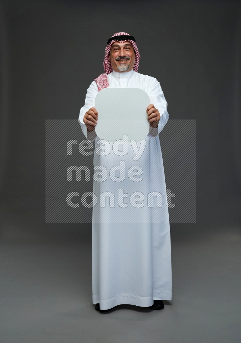 Saudi man with shomag Standing holding social media sing on gray background