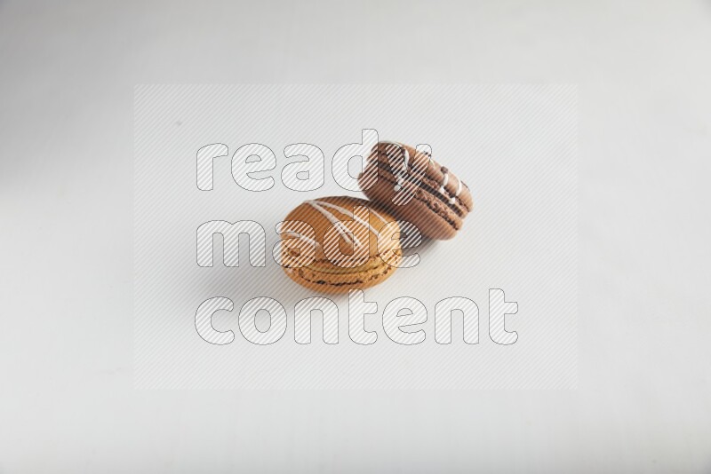 45º Shot of of two assorted Brown Irish Cream, and Brown white Chocolate Caramel macarons on white background