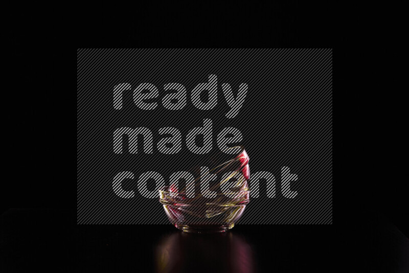 Glassware with rim light in red and yellow against black background