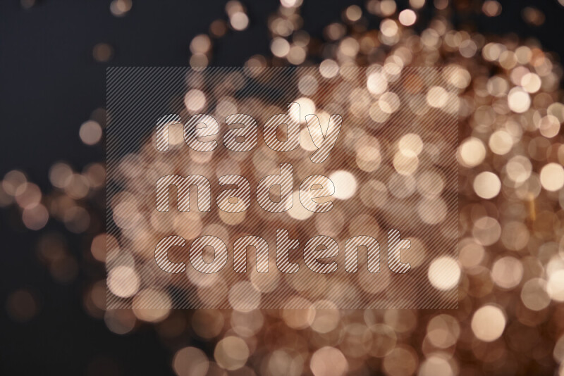 Bronze shimmering fragments of glass scattered on a black background