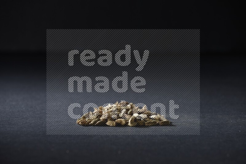 Cardamom in a triangle shape on black flooring