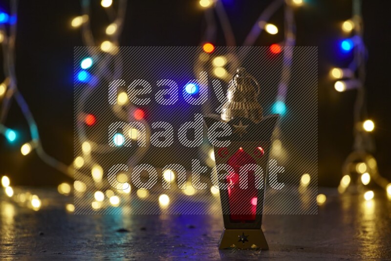 A traditional ramadan lantern surrounded by glowing fairy lights in a dark setup