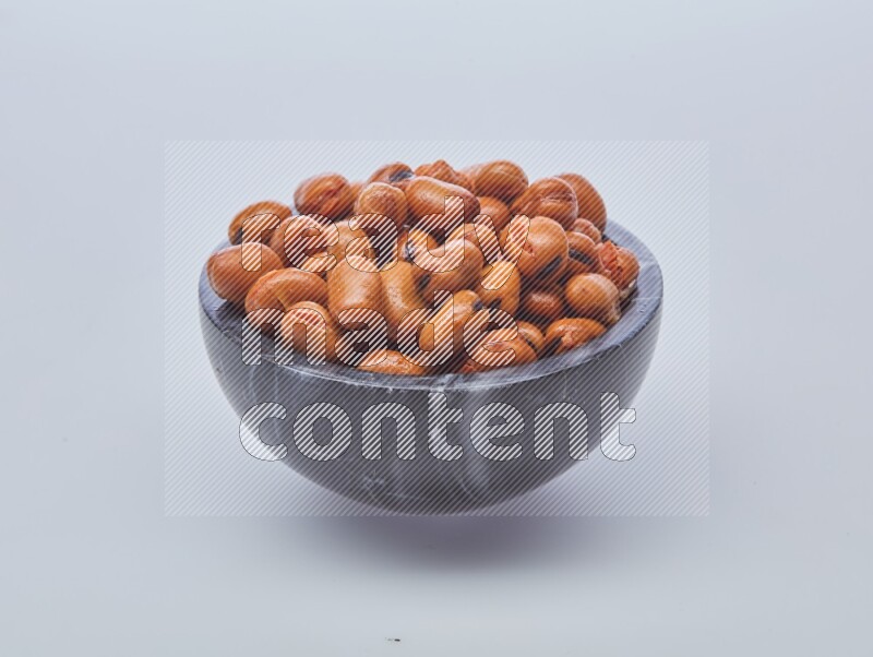 Close up shot of cooked fava beans (foul) in a container on white background