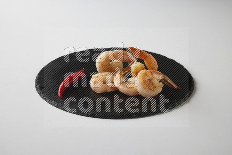 five grilled shrimps  on a black slate direct  on a white back ground