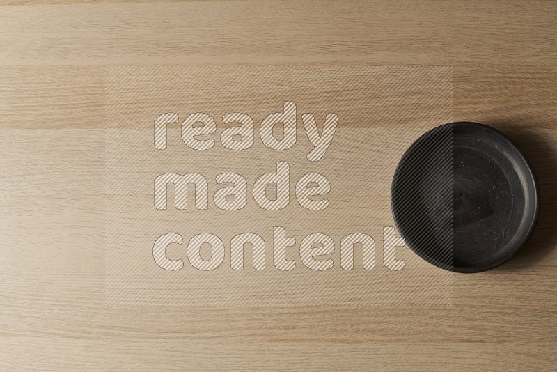 Top View Shot Of A Black Pottery Oven Plate on Oak Wooden Flooring