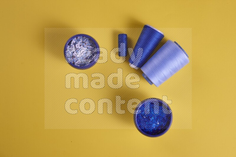 A blue collection of sewing and tailoring tools arranged on a yellow background