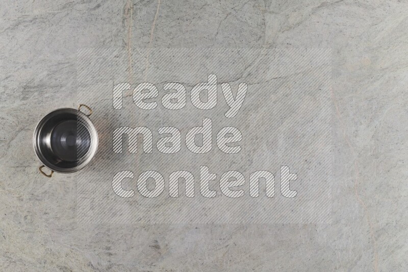 A small copper pot on grey marble background