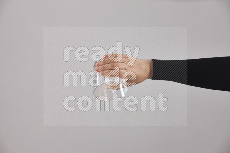 امرأة ترتدي عباءة سوداء تحمل أدوات زجاجية مختلفة في أوضاع متعددة