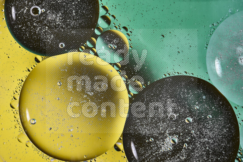 Close-ups of abstract oil bubbles on water surface in shades of green and yellow