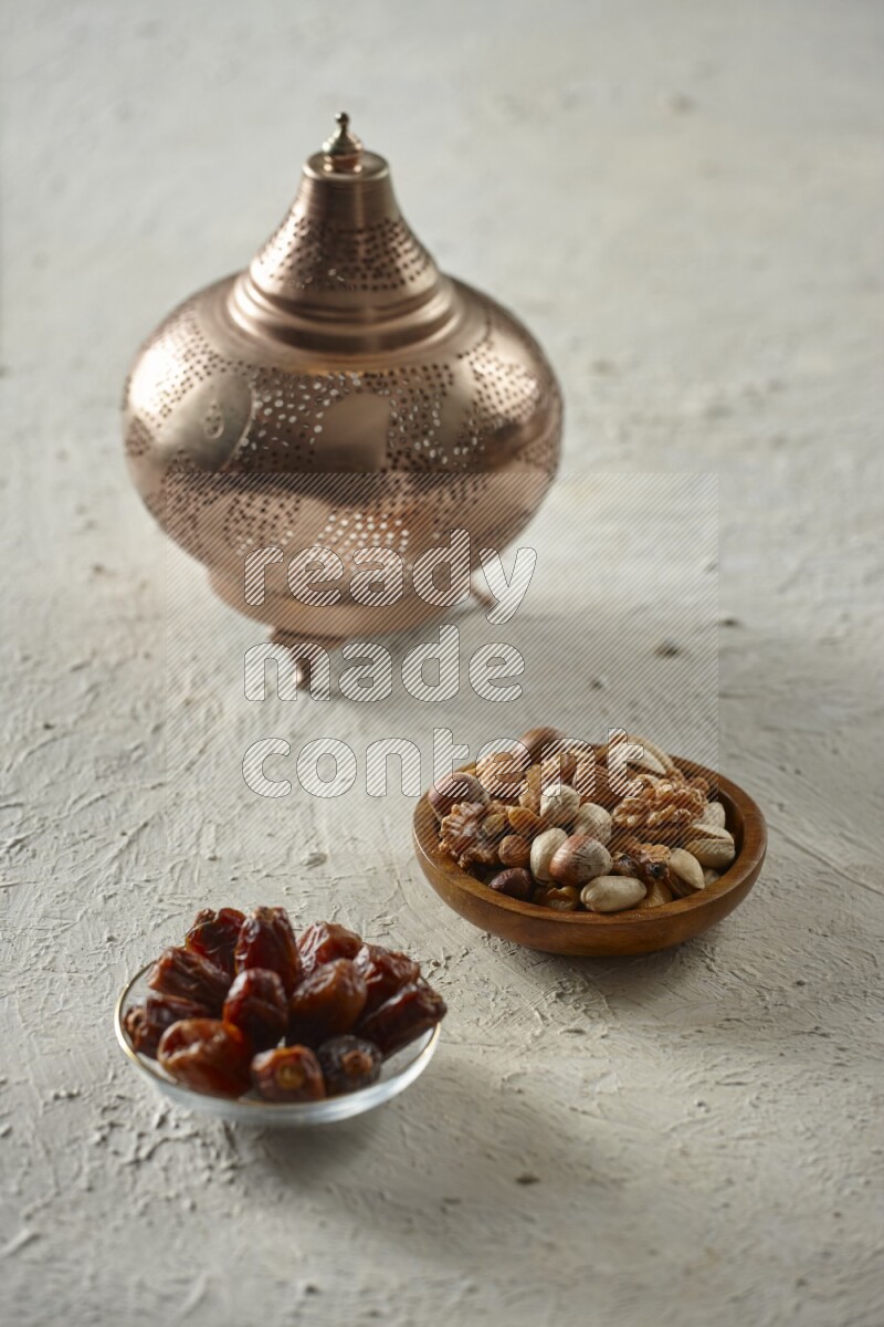 A golden lantern with different drinks, dates, nuts, prayer beads and quran on textured white background