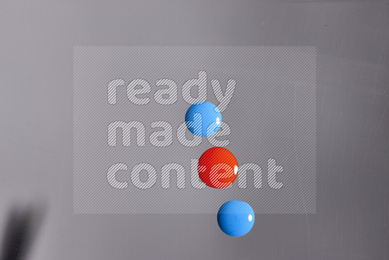 Close-ups of abstract red and blue paint droplets on the surface