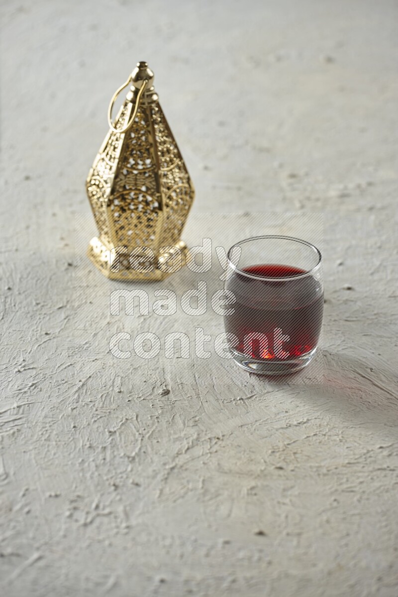 A golden lantern with different drinks, dates, nuts, prayer beads and quran on textured white background