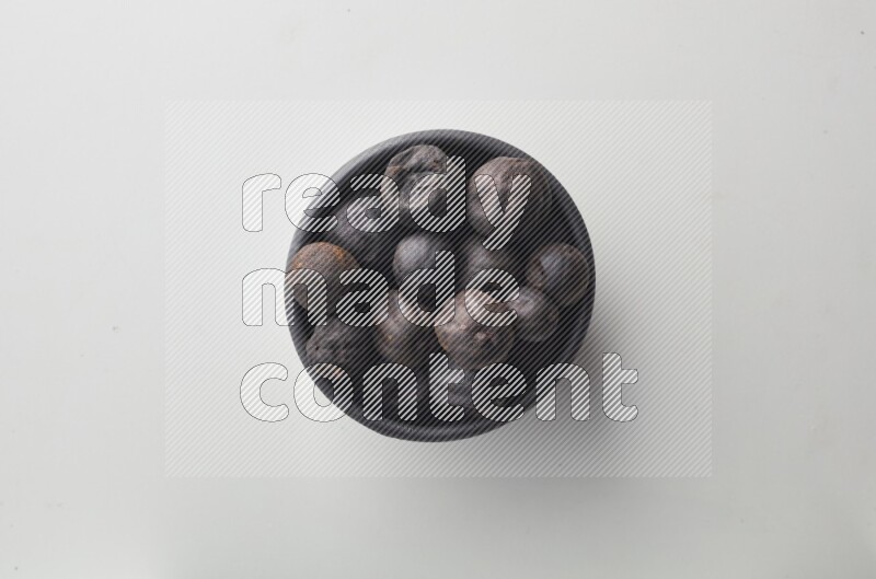 Top-view shot of dried lime (loomi) in a container on white background