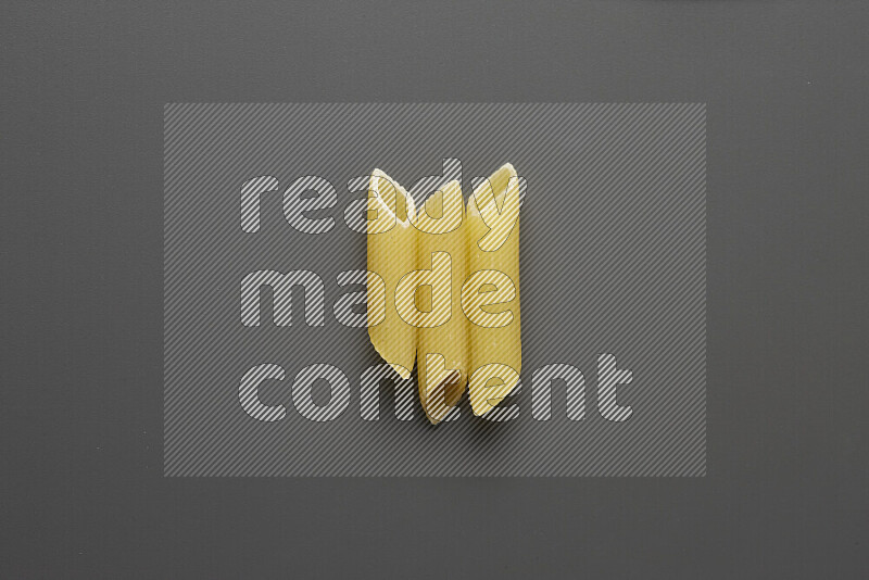 Penne pasta on grey background