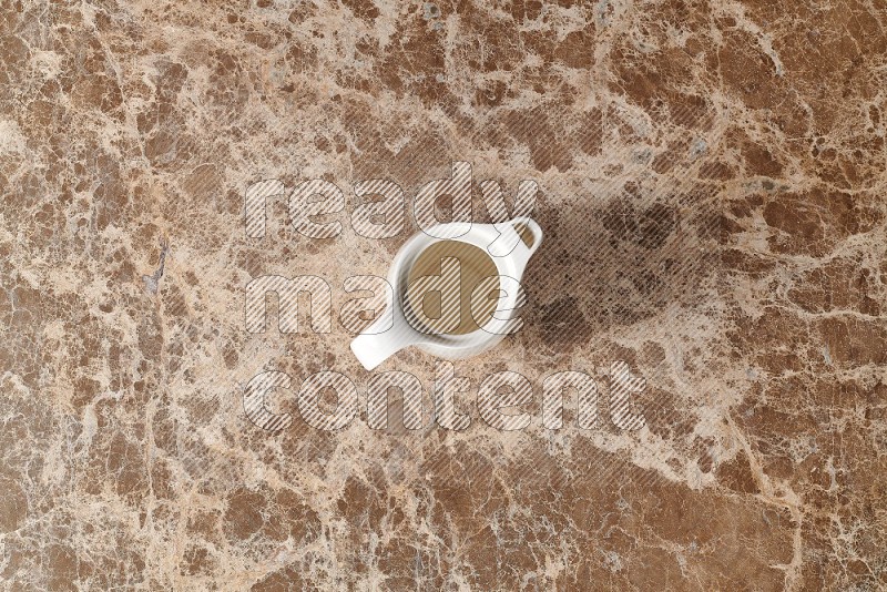 Top View Shot Of A Ceramic Milk Jug On beige Marble Flooring