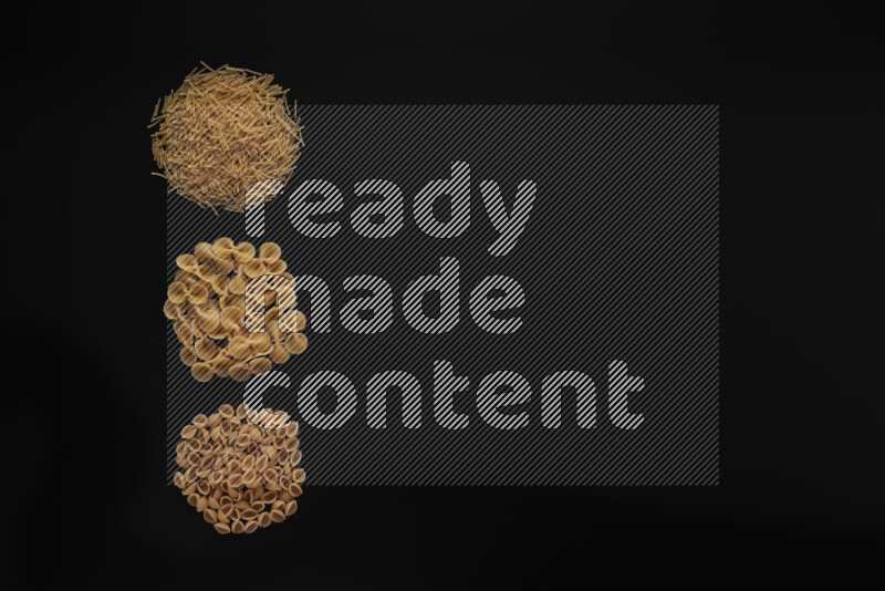 Different pasta types in 3 bunches on black background