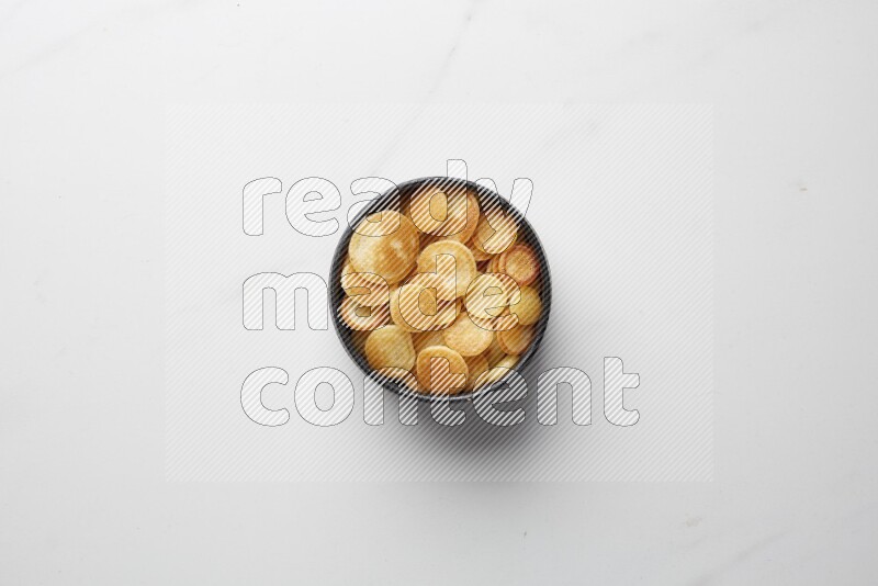 Top-view shot of plain cereal pancakes in a round bowl on white background