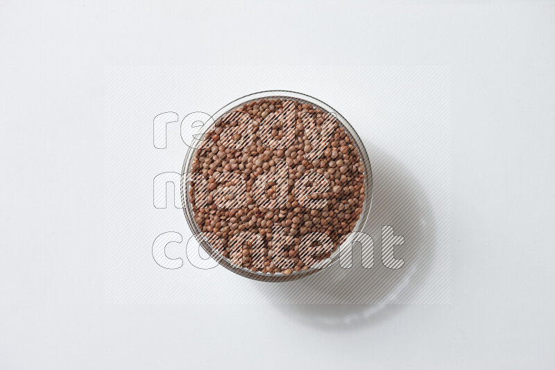 Brown lentils on white background