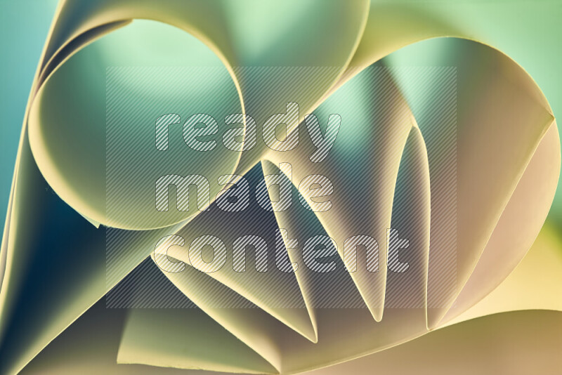 An artistic display of paper folds creating a harmonious blend of geometric shapes, highlighted by soft lighting in green and warm tones