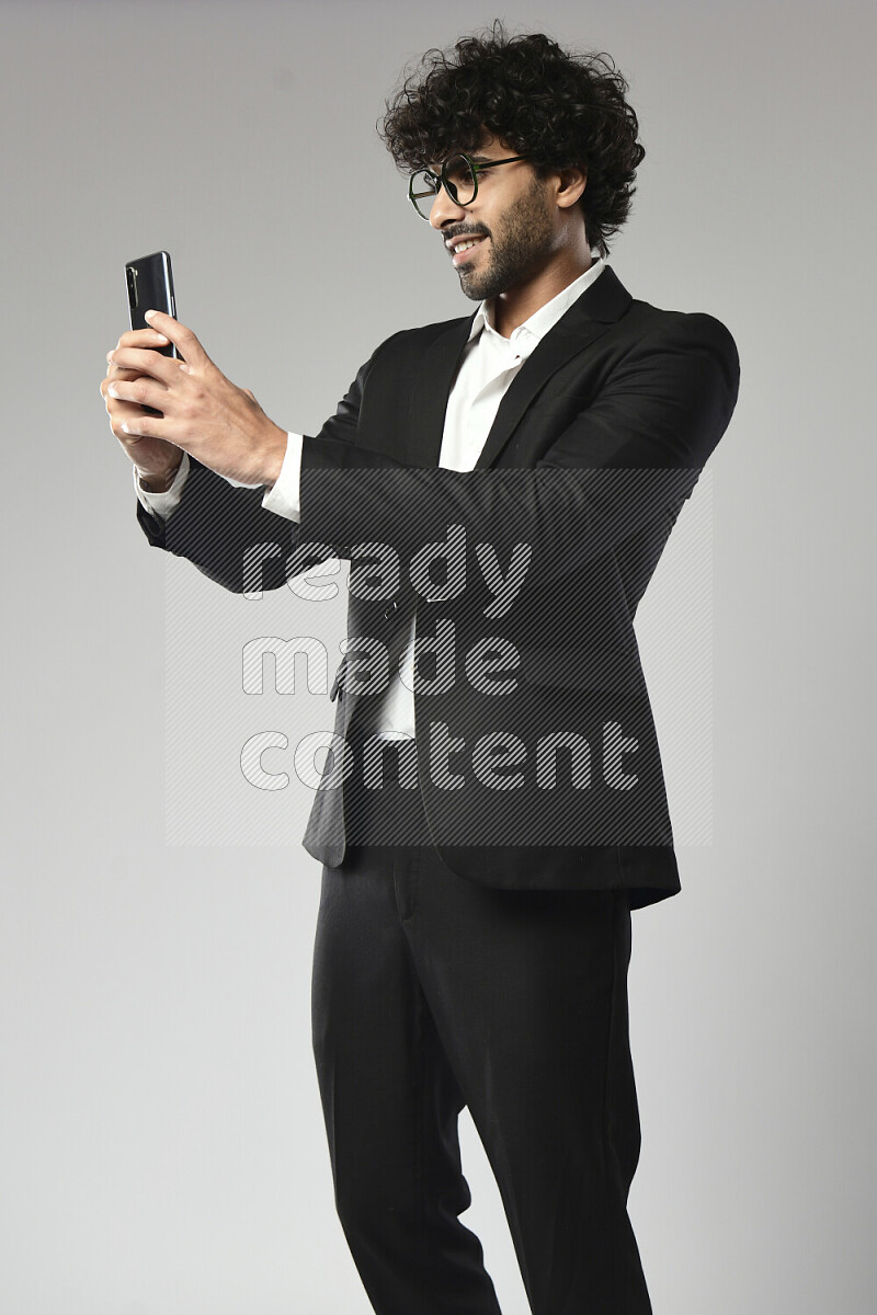 رجل يرتدي ملابس رسمية يلتقط صورة شخصية علي خلفية بيضاء