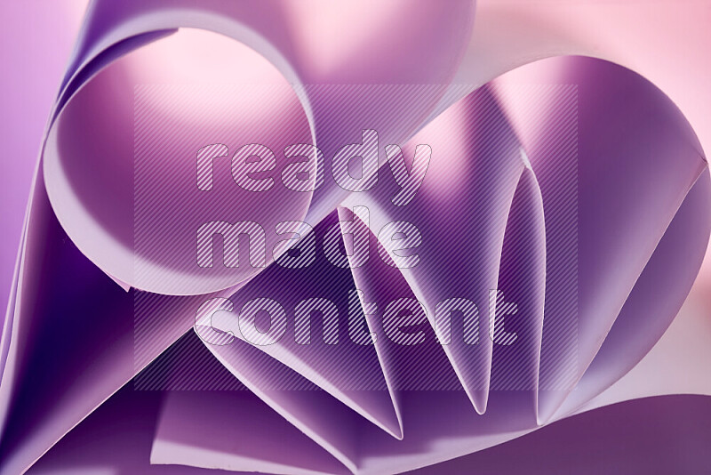An artistic display of paper folds creating a harmonious blend of geometric shapes, highlighted by soft lighting in purple tones