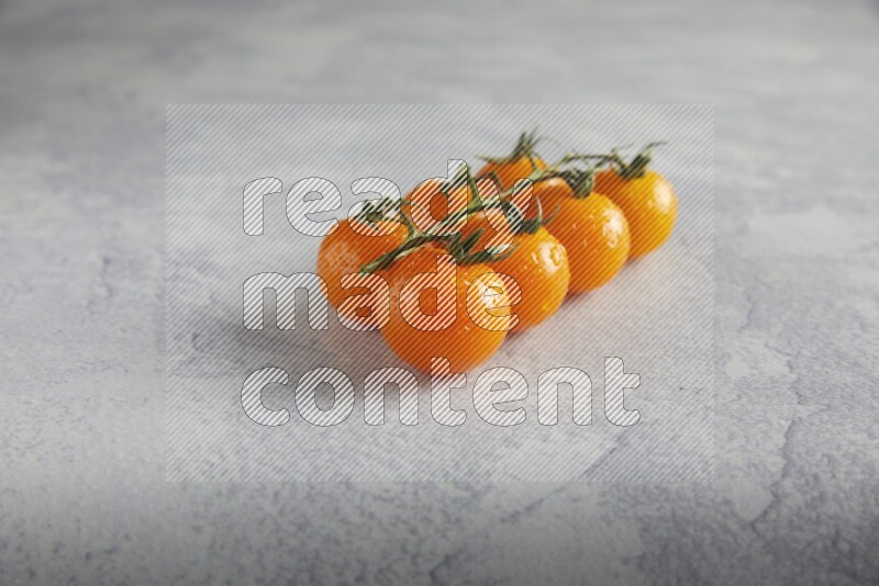 Orange cherry tomato vein on a light grey textured background 45 degree