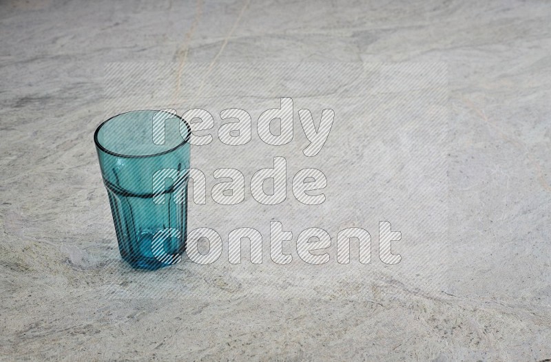 A Turquoise Glass On Grey Marble Flooring