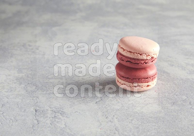 45º Shot of two Pink Litchi Raspberry macarons  on white  marble background