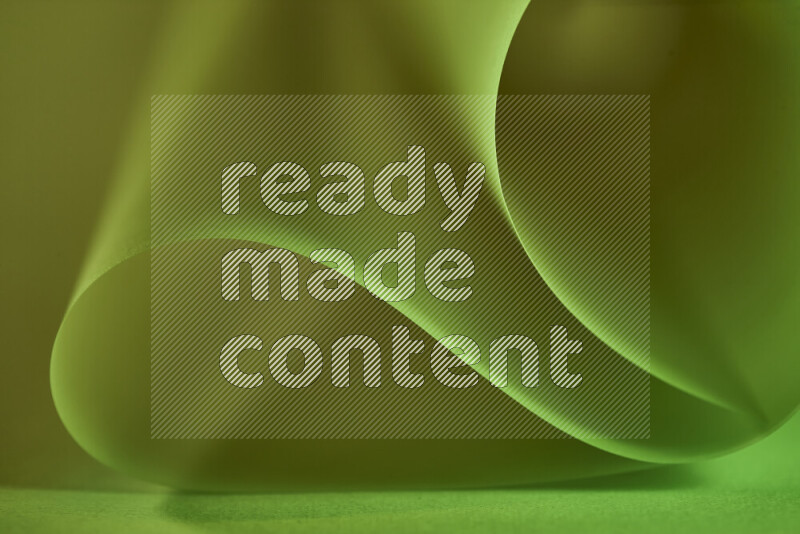 An abstract art piece displaying smooth curves in green and yellow gradients created by colored light