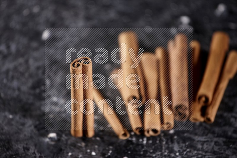 Cinnamon sticks on a textured black background