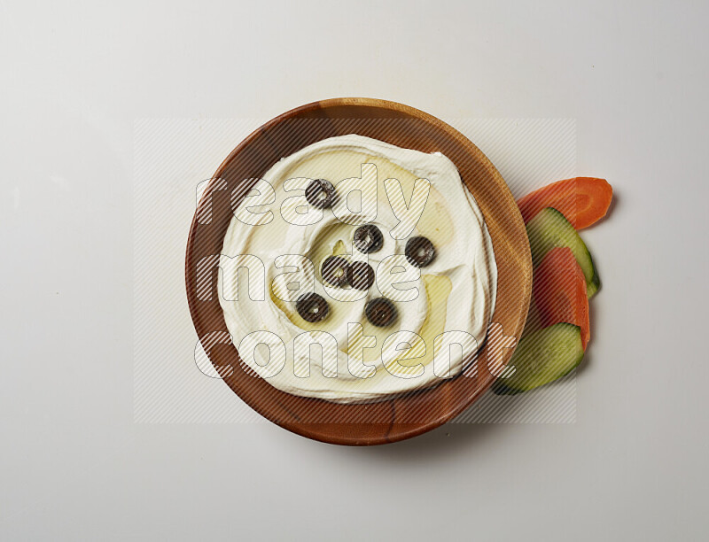 Lebnah garnished with sliced olives in a wooden plate on a white background