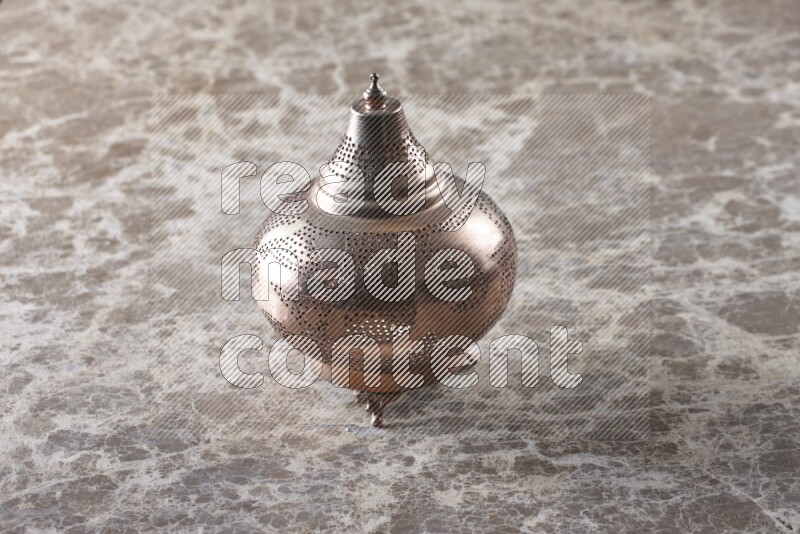 A lantern placed on a beige marble background