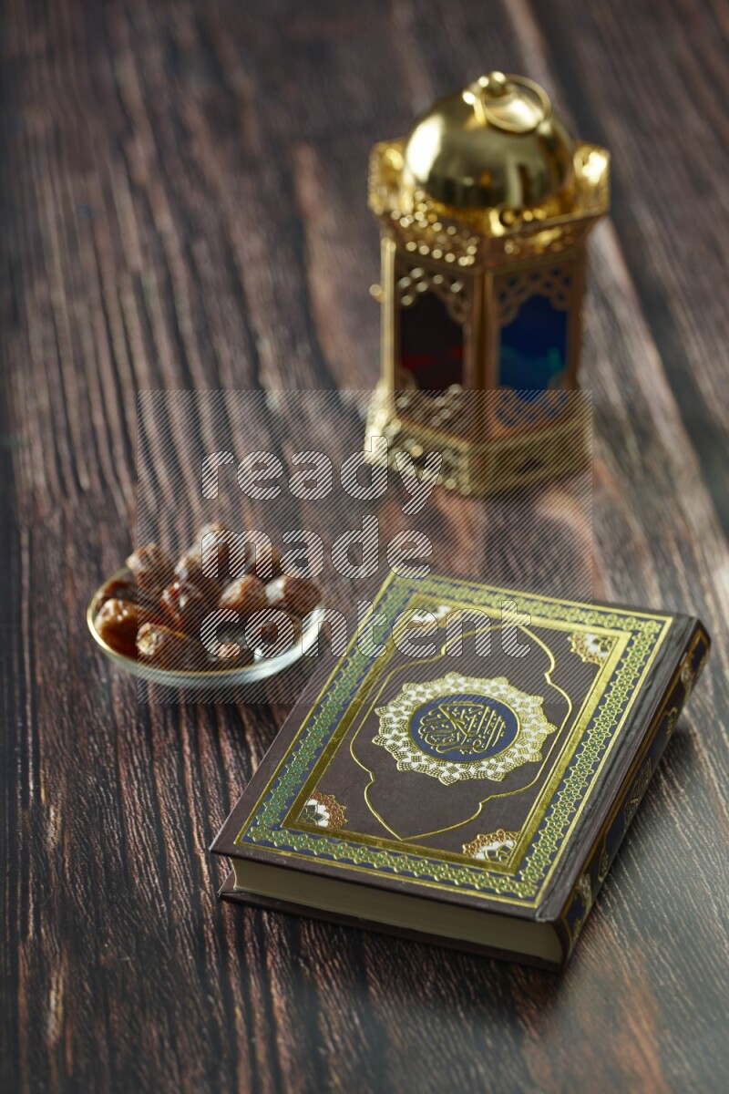 A golden lantern with different drinks, dates, nuts, prayer beads and quran on brown wooden background