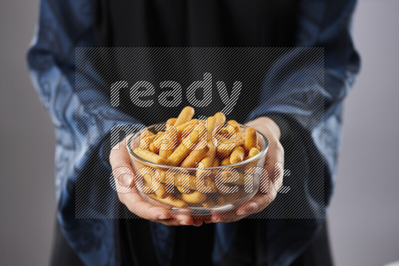 Woman in abaya holding different kinds of snacks in different positions